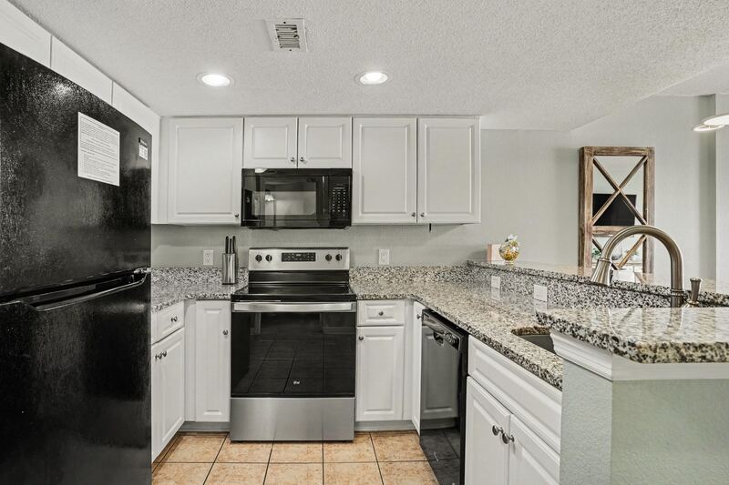 Kitchen with white cabinets, granite counters and stainless range